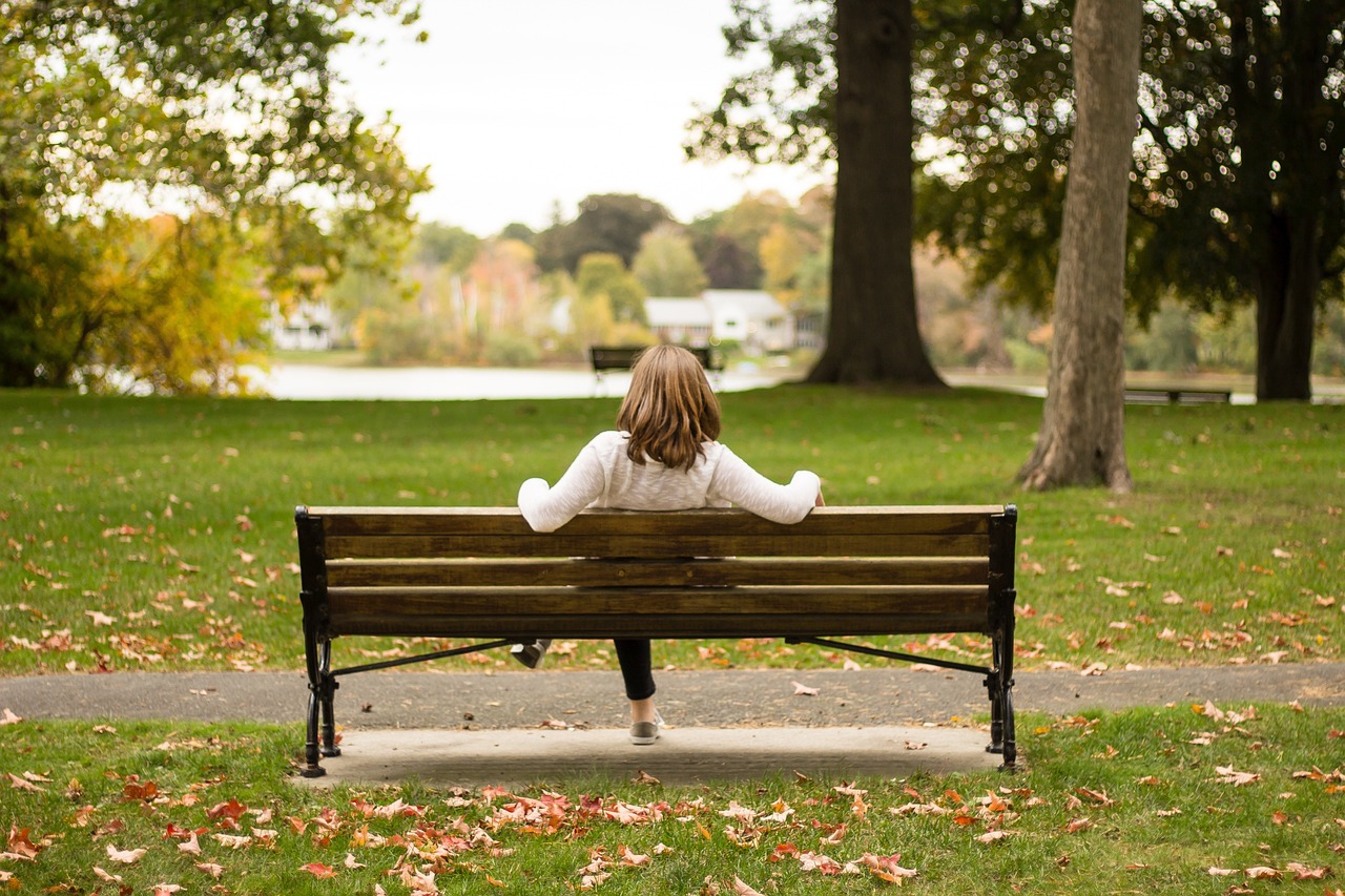 Woman sitting on bench at park in Yonge and St. Clair. 