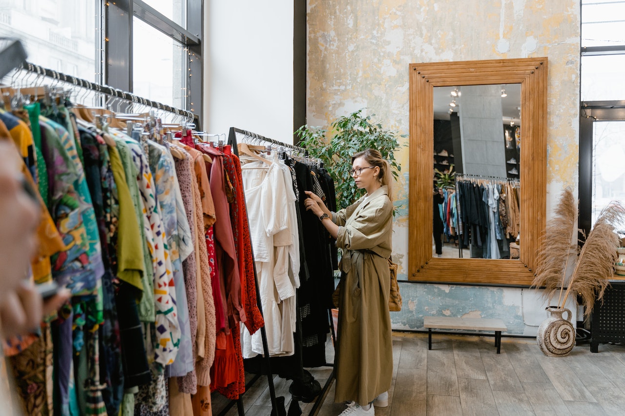 Woman in brown trench coat shopping for clothes. 