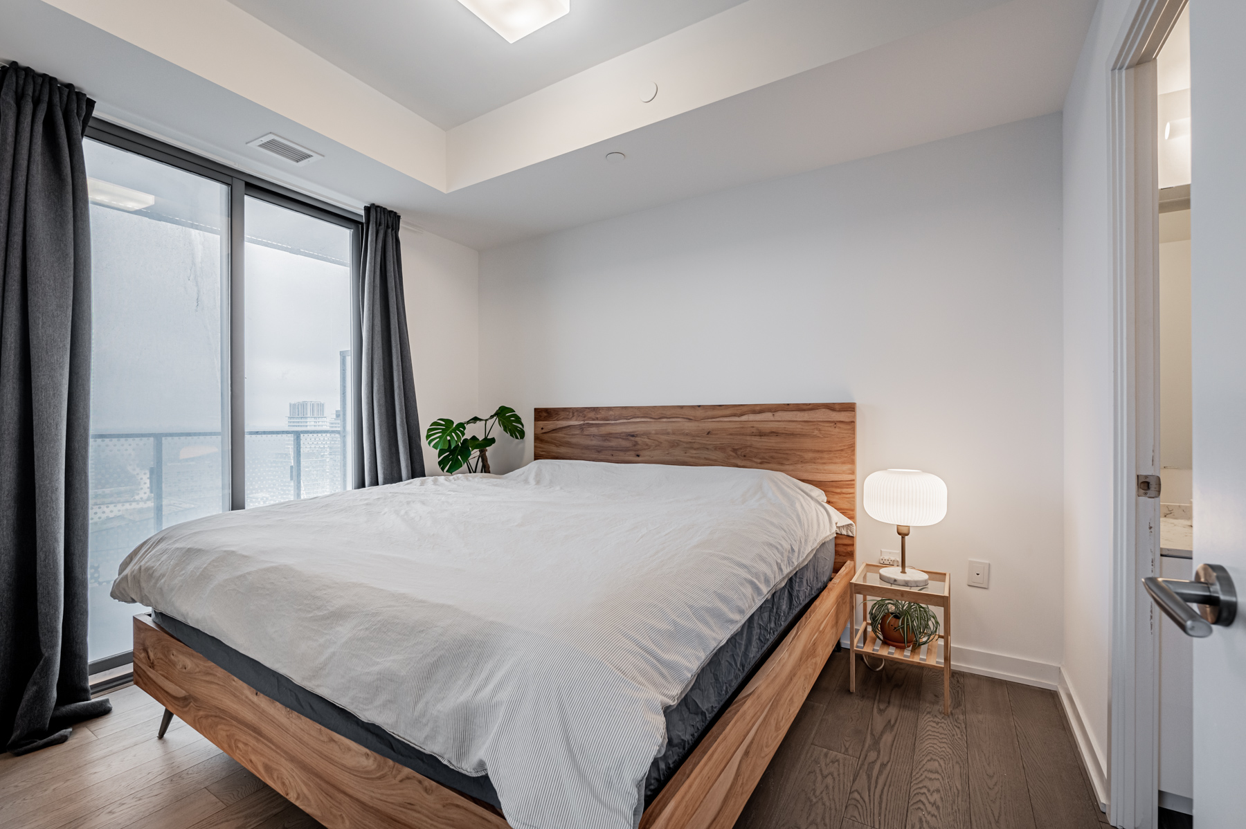Primary condo bedroom with large bed and balcony access – 11 Wellesley St Suite 5808.