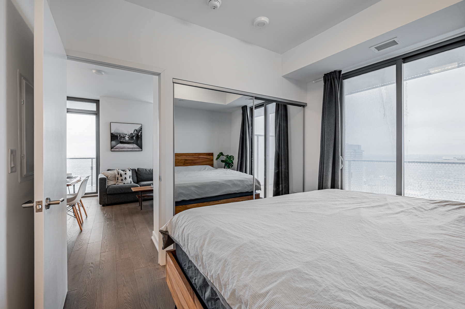 Condo bedroom closet with sliding mirror doors.