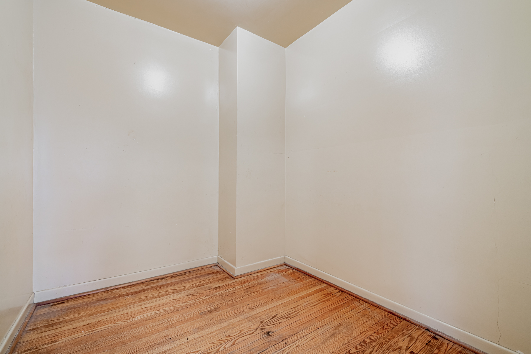 Empty bedroom with hardwood floors.