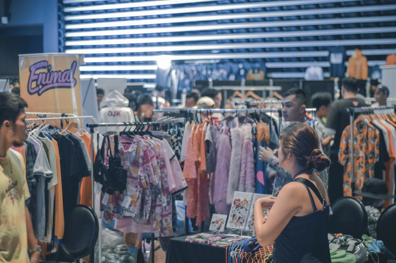 People shopping for clothes in crowded store.