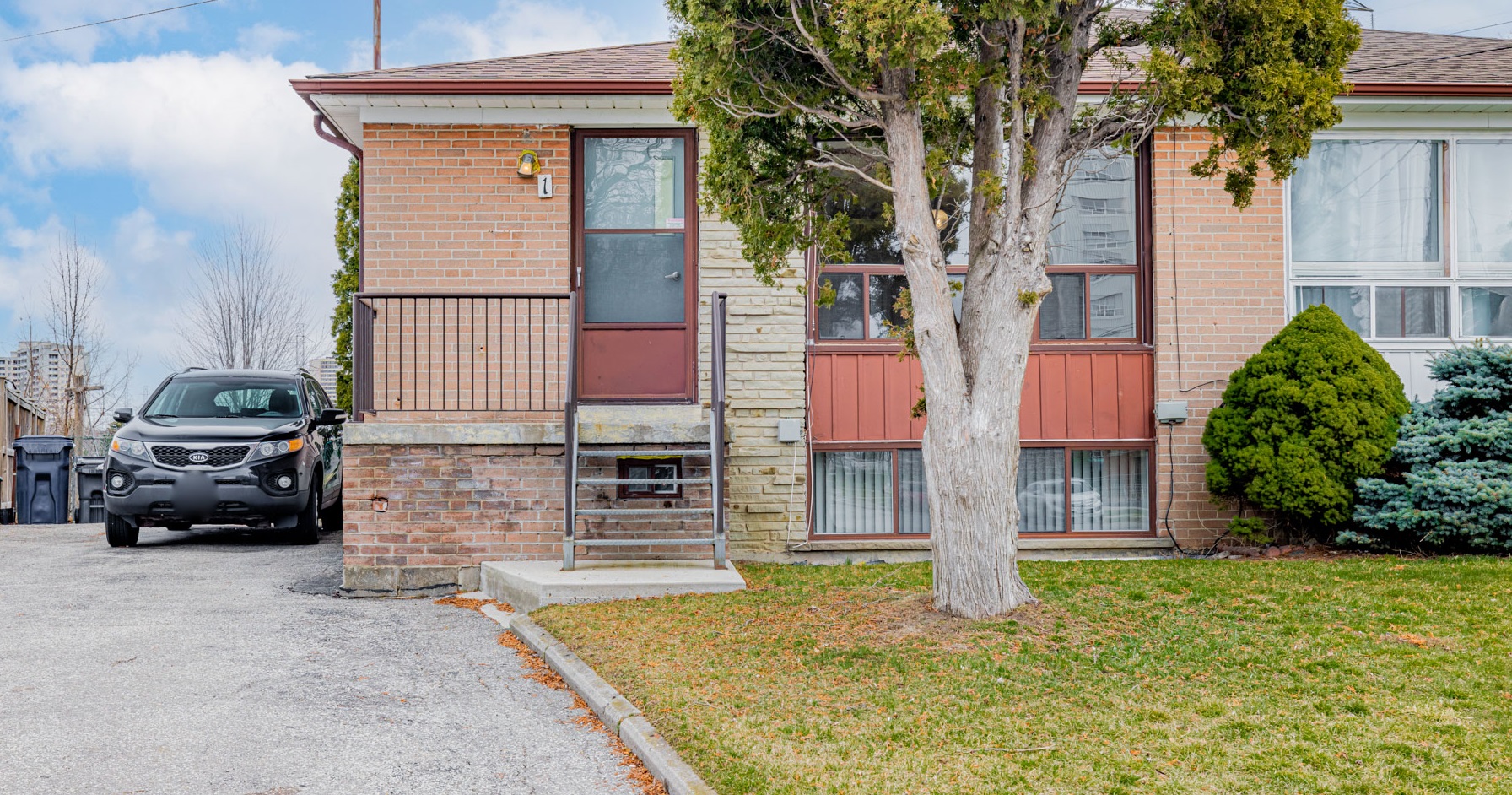 Red brick facade of 1 Stong Court with driveway and frontyard.