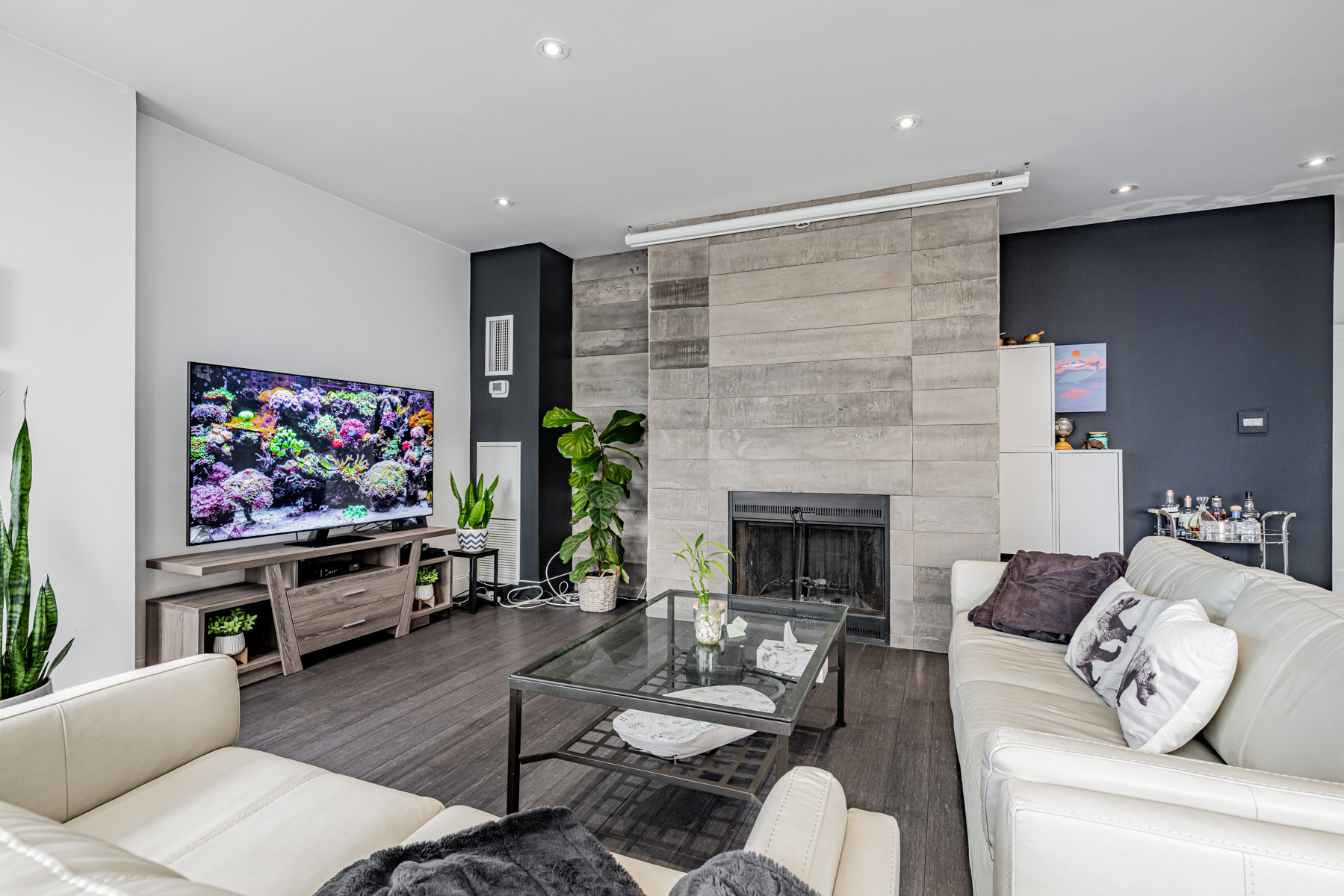 Penthouse living room with concrete feature wall and fireplace.