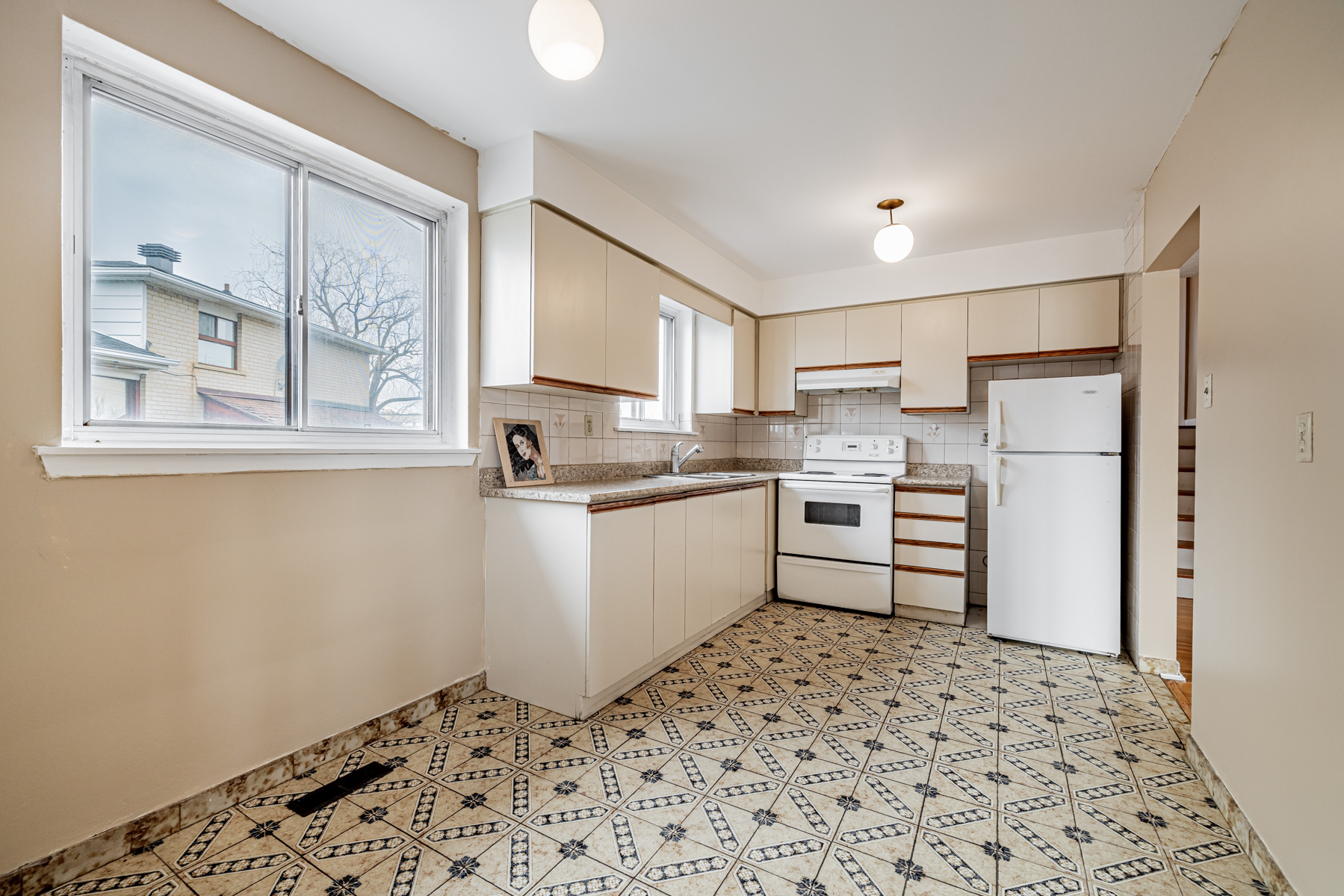 Kitchen with two windows and two ceiling lights.