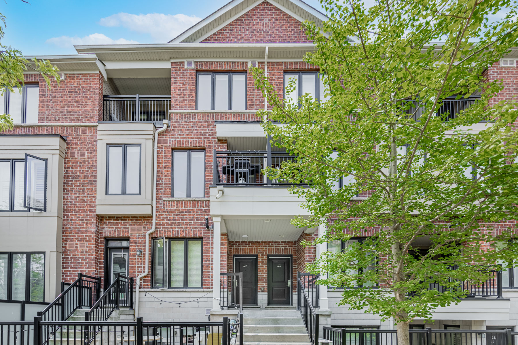 Red-brick exterior of 20 Carnation Ave, a 2-storey stacked townhouse.