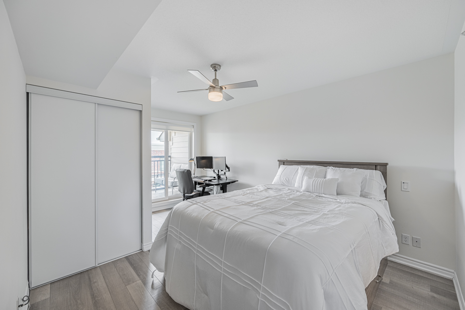 20 Carnation Ave Unit 42 – large primary bedroom with vinyl floors, bed and closet.