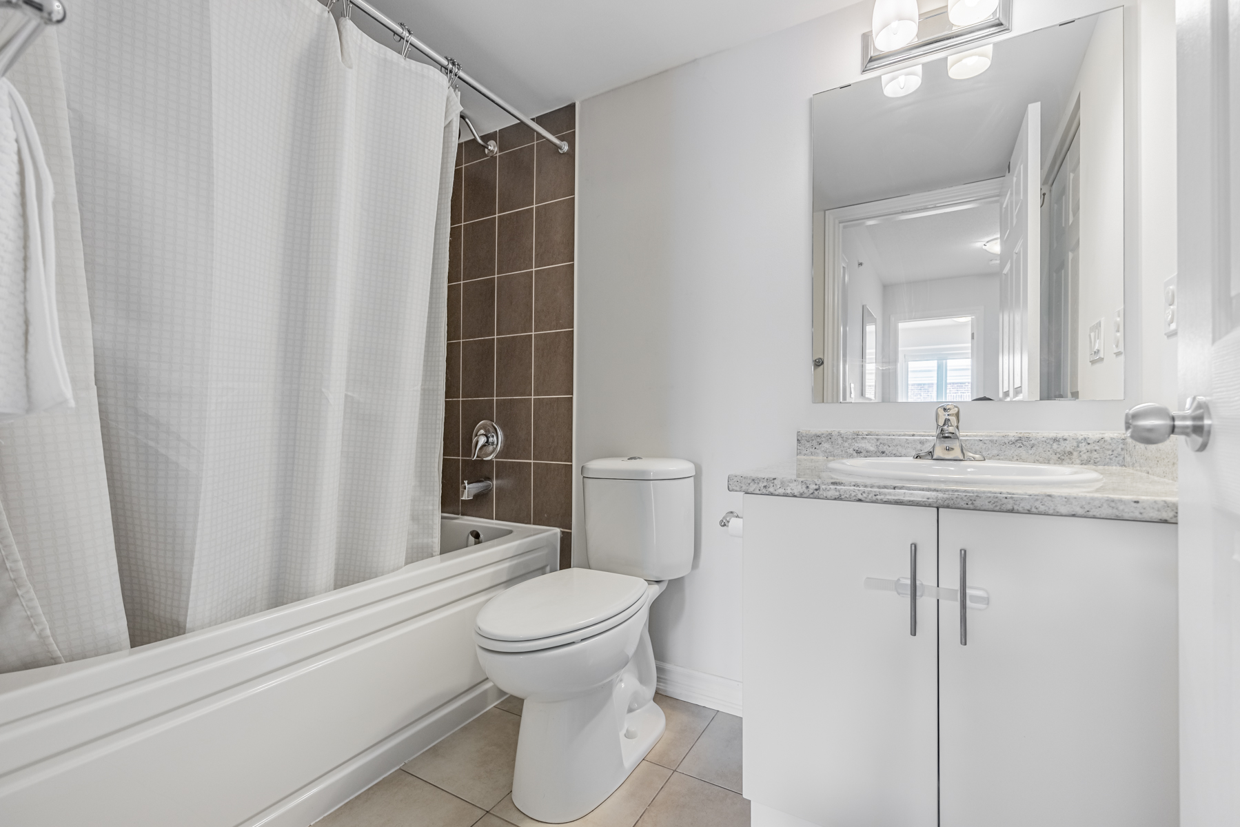 20 Carnation Ave Unit 42 – 2nd bathroom with ceramic floors and bathtub with dark tiles.