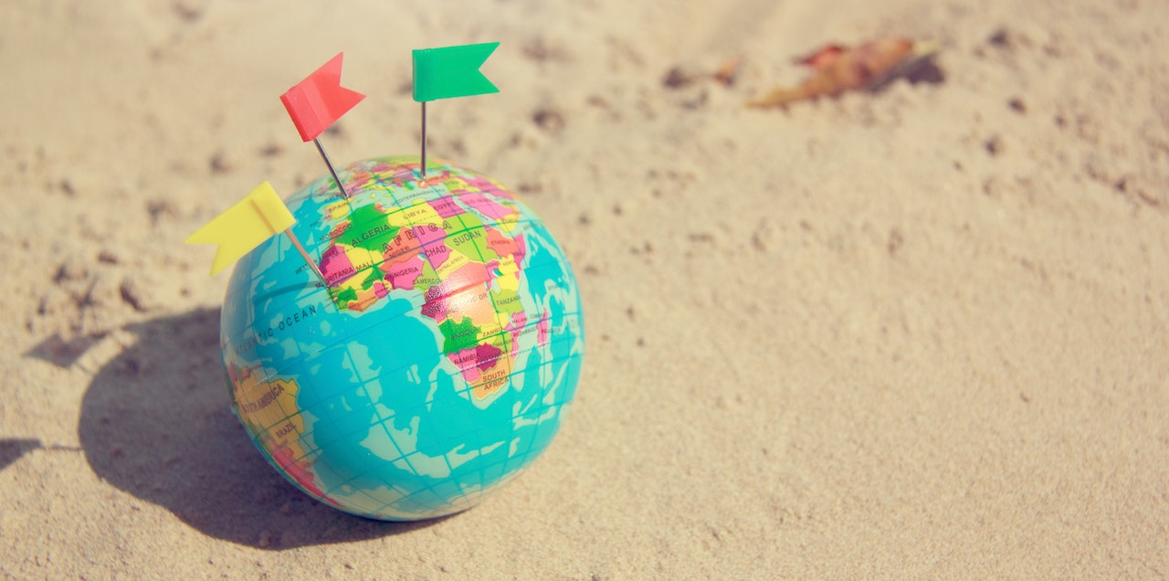 Globe with flags on sandy beach to show only Canadians can open FHSA.