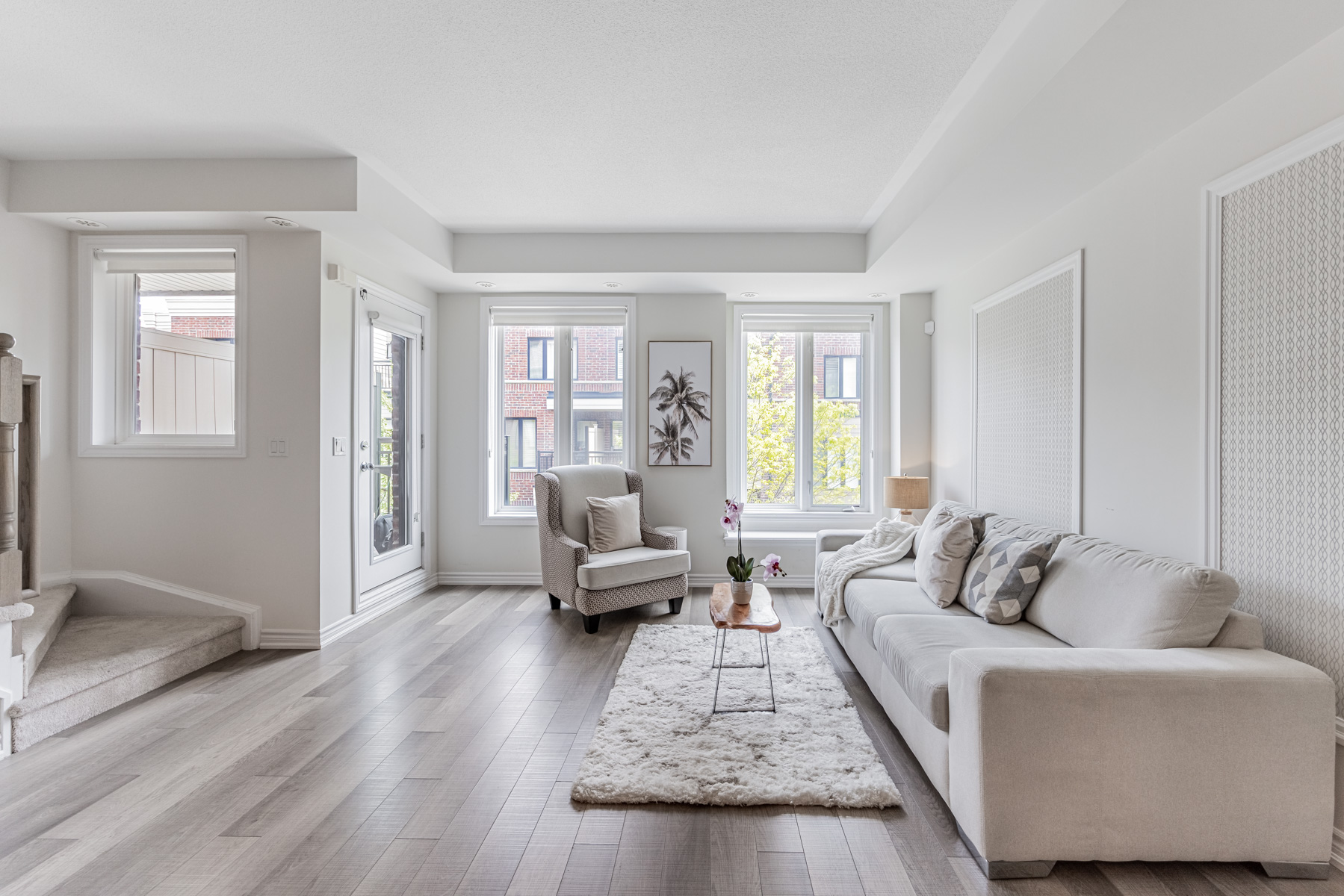 Townhouse living room lit by 4 different windows and doors.