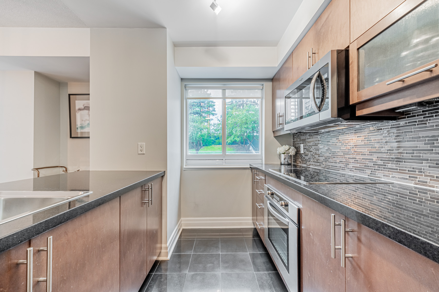 Kitchen with window showing trees.