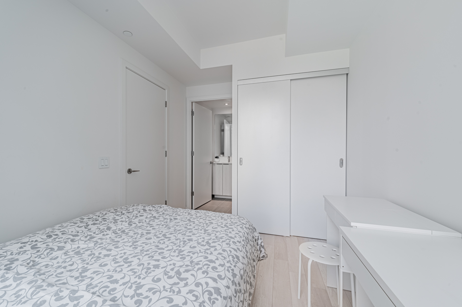 Condo bedroom with large double-door closet.