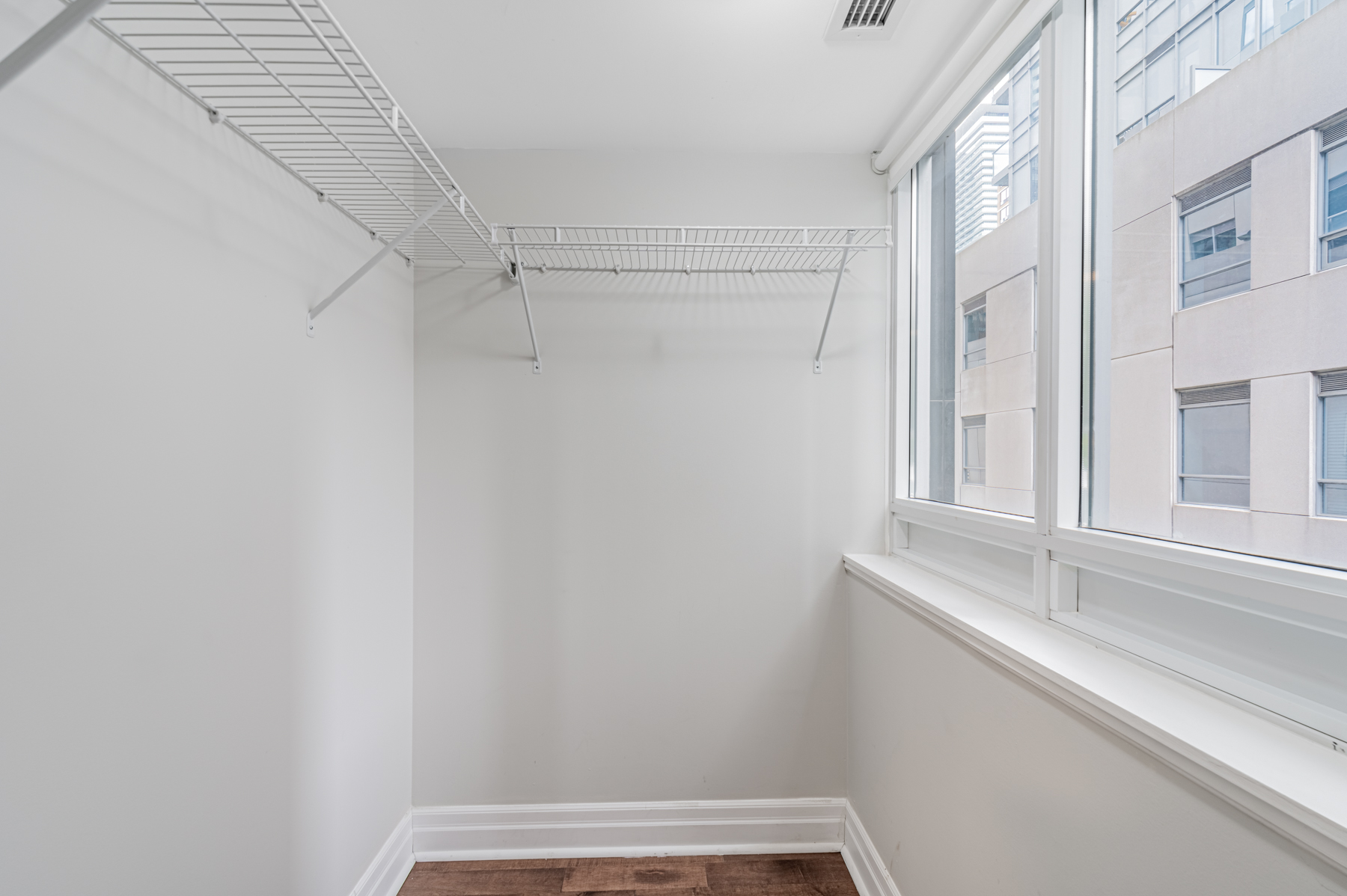 Large empty walk-in closet with built-in shelves.