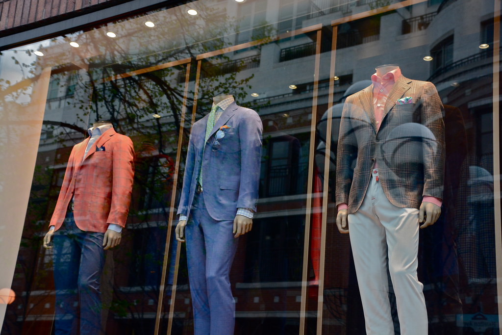 Store display of male mannequins in suits. 