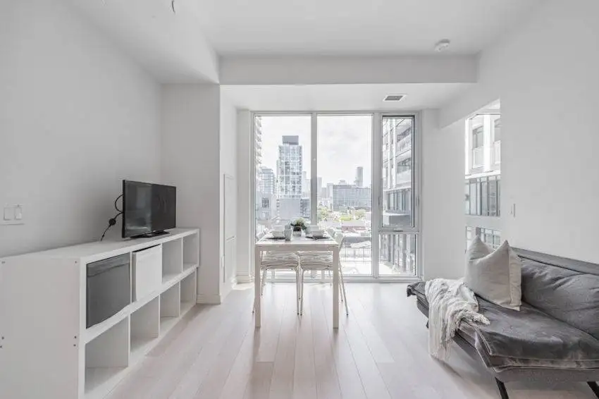 Condo unit with tall windows showing view of Toronto.