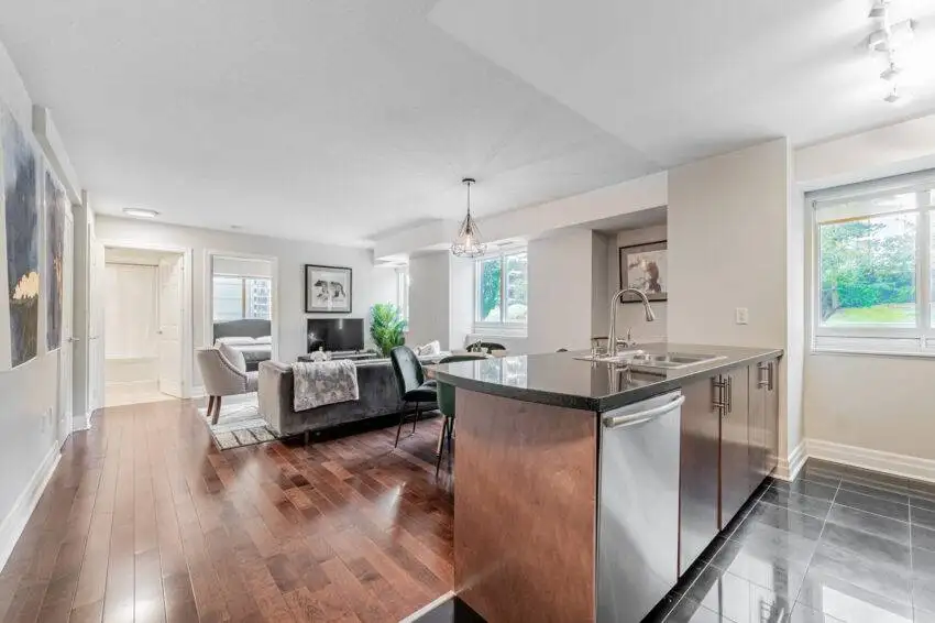 Condo living and dining room with dark brown hardwood floors.
