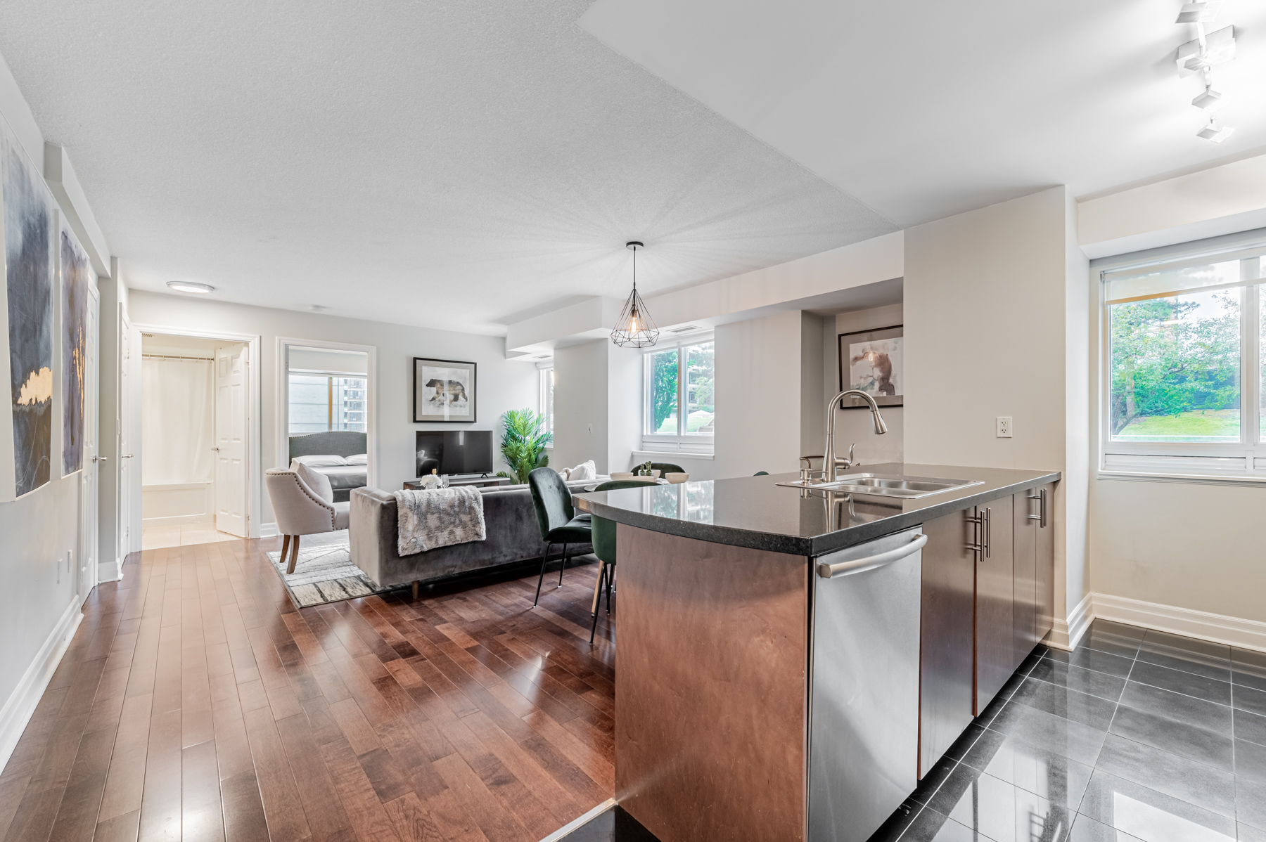 Condo living and dining room with dark brown hardwood floors.