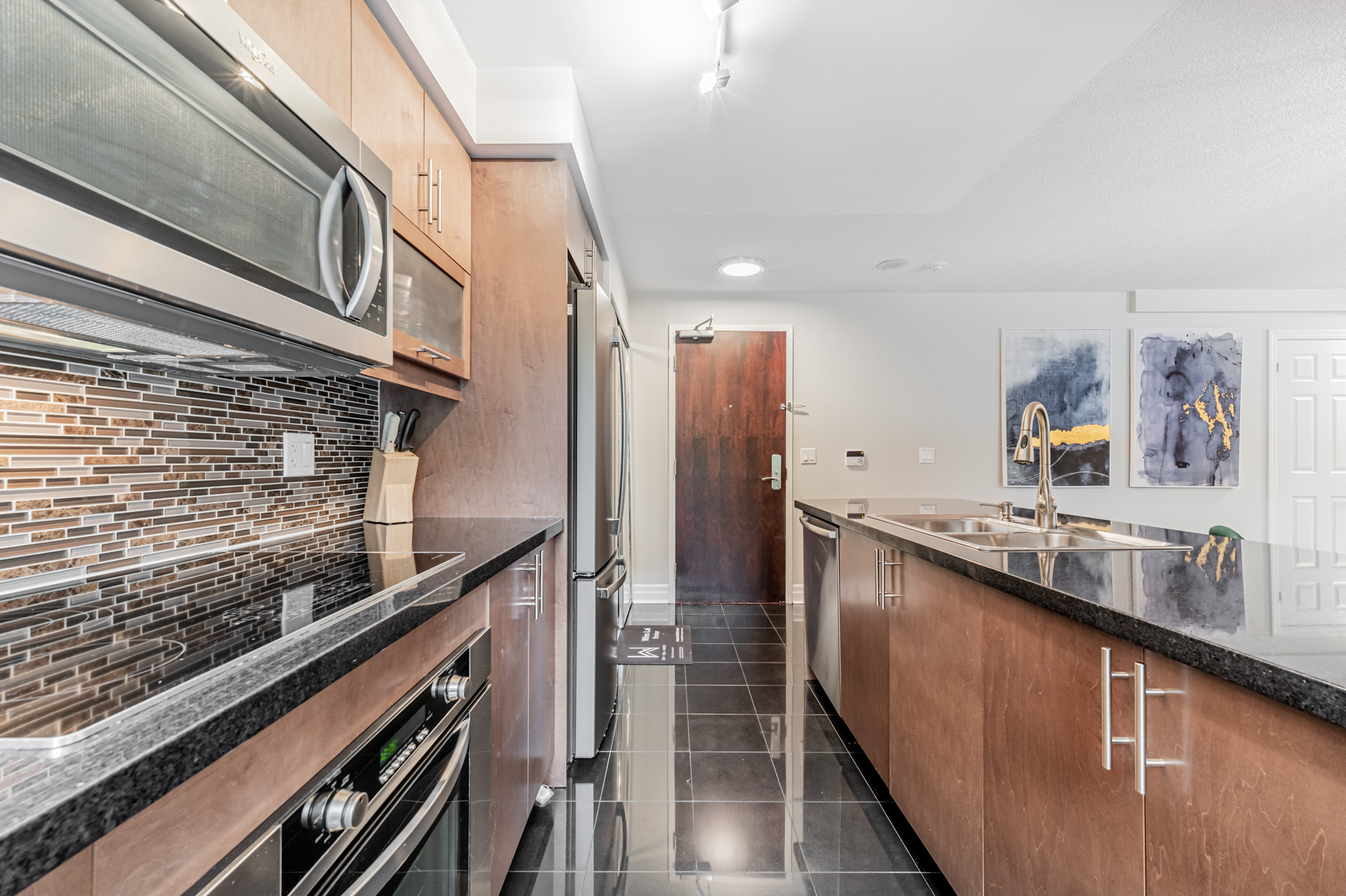 Condo kitchen with black ceramic tiles and black quartz counters.