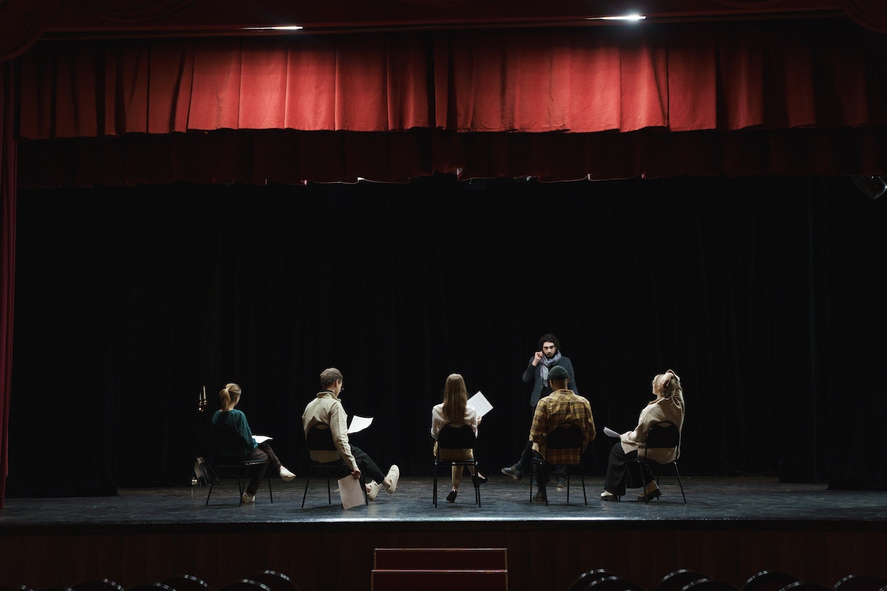 Actors rehearsing for play on stage. 