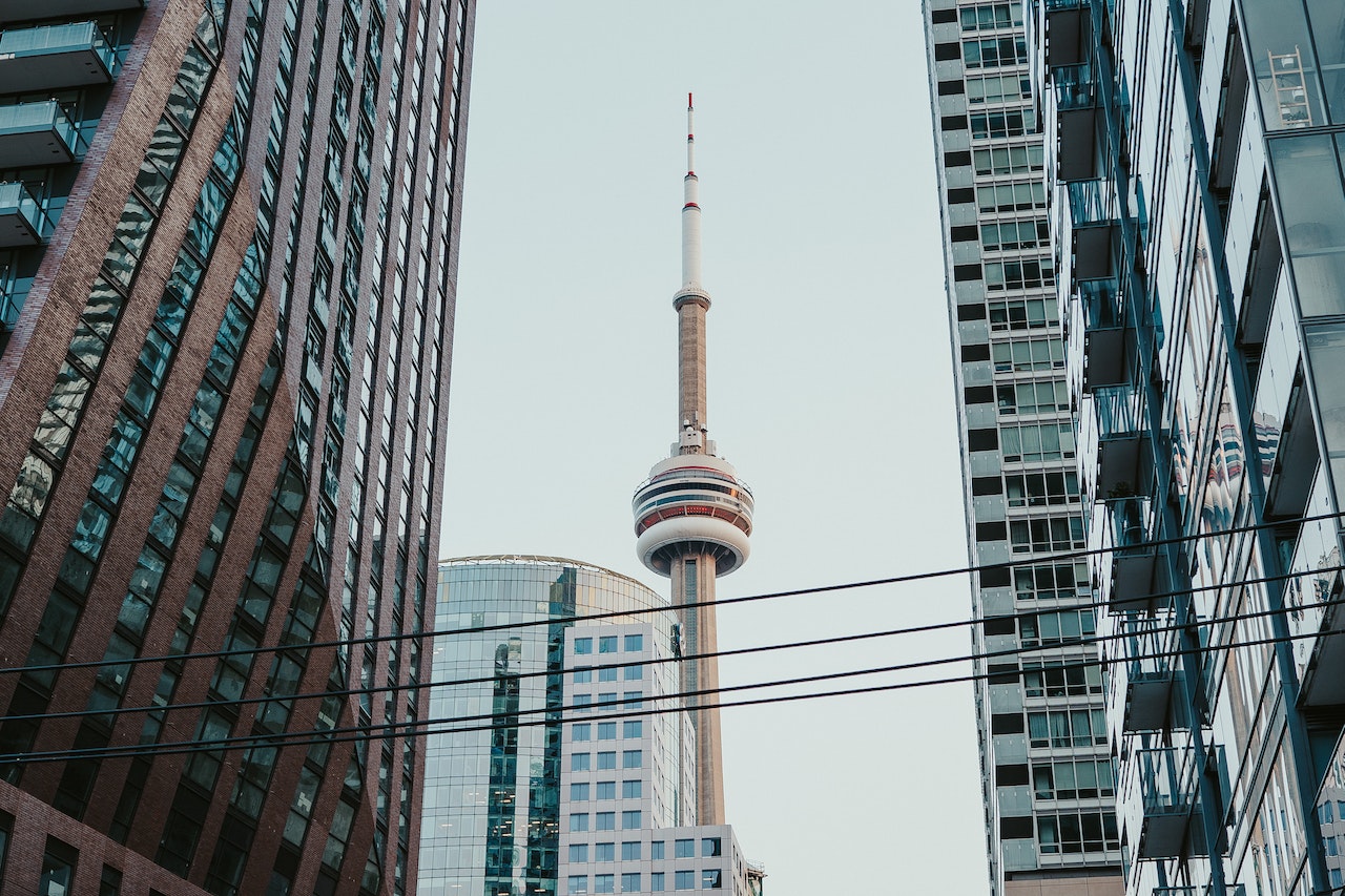 Upper half of the CN Tower rising among buildings in Toronto.