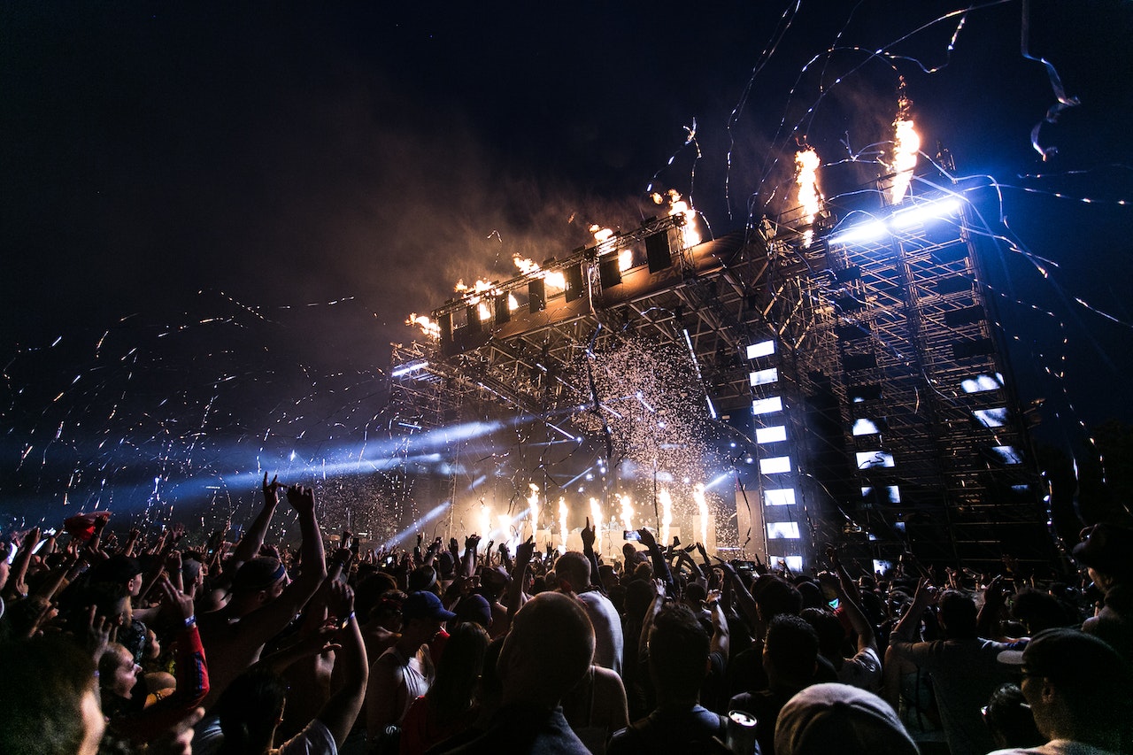 Crowd watching stage performance and fireworks.