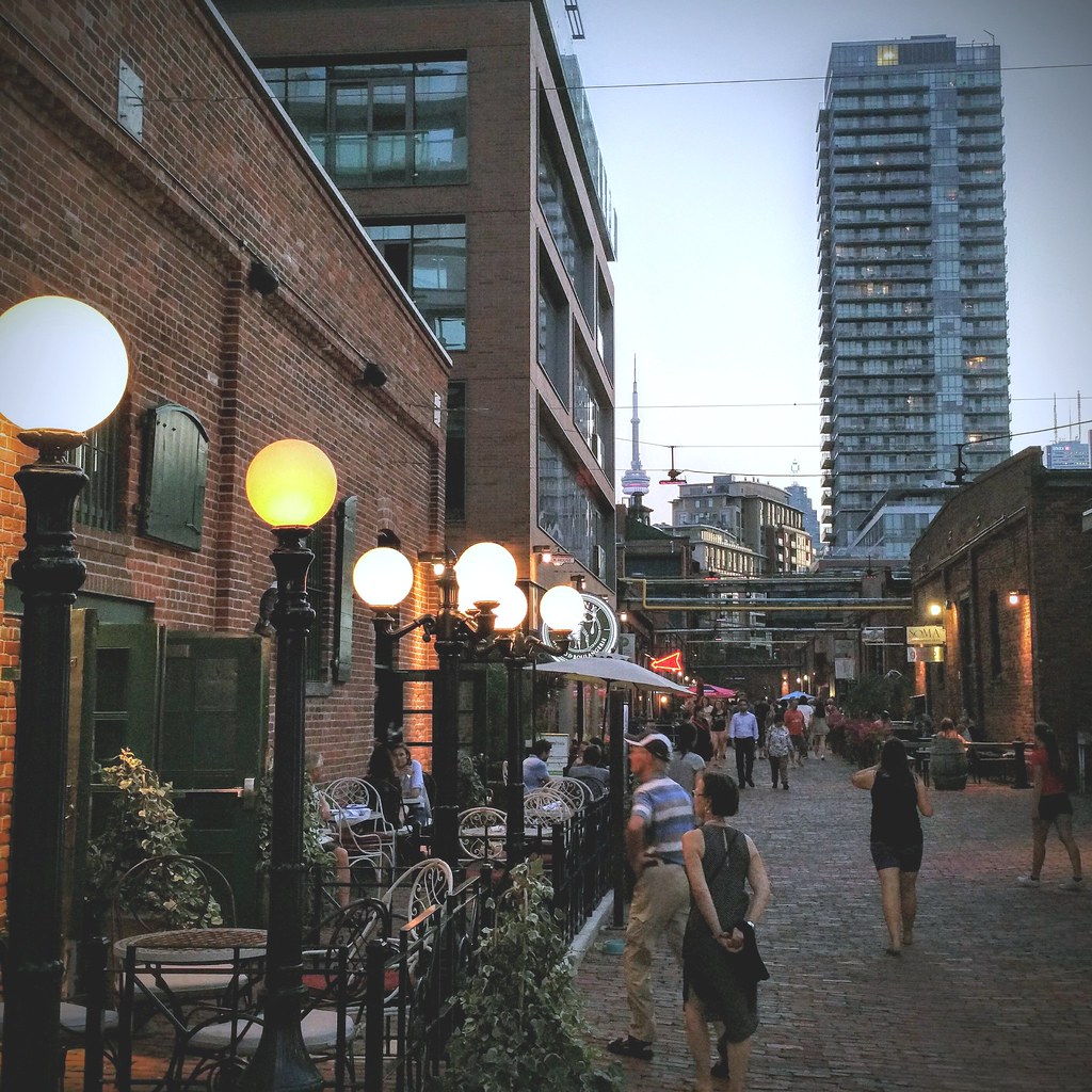 People in Toronto's Distillery District in foreground; CN Tower in background.