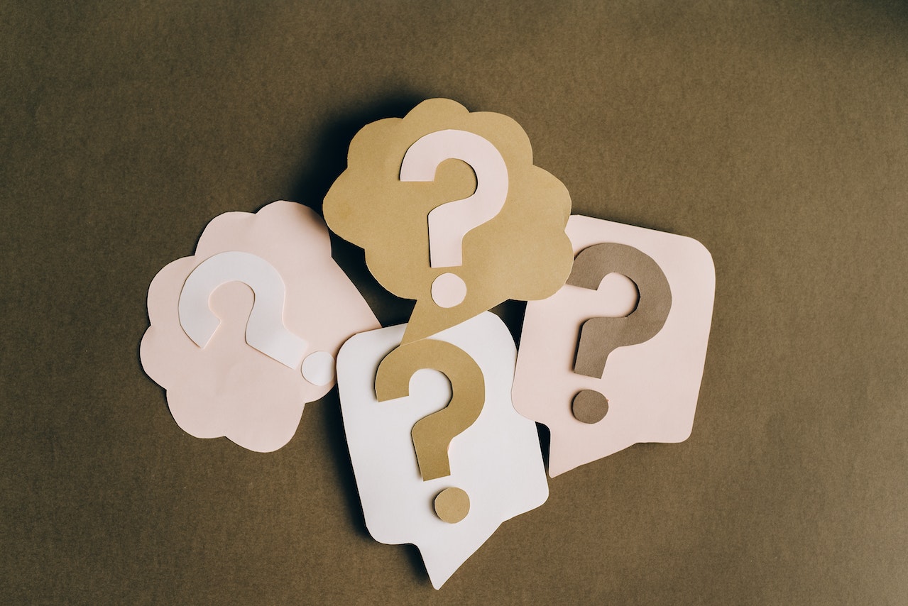 Cutouts of question marks on brown background.