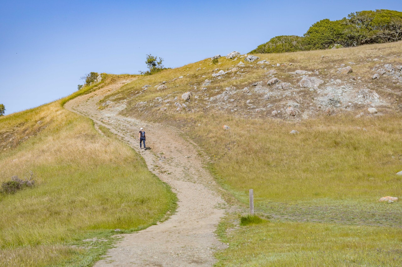 Long distance shot of person climbing hill.