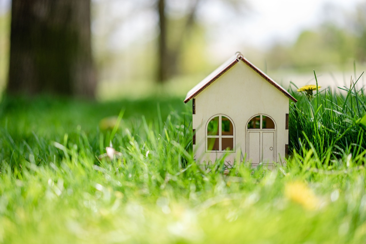 White toy house on grass to show impact of June 2023 interest rate hike.