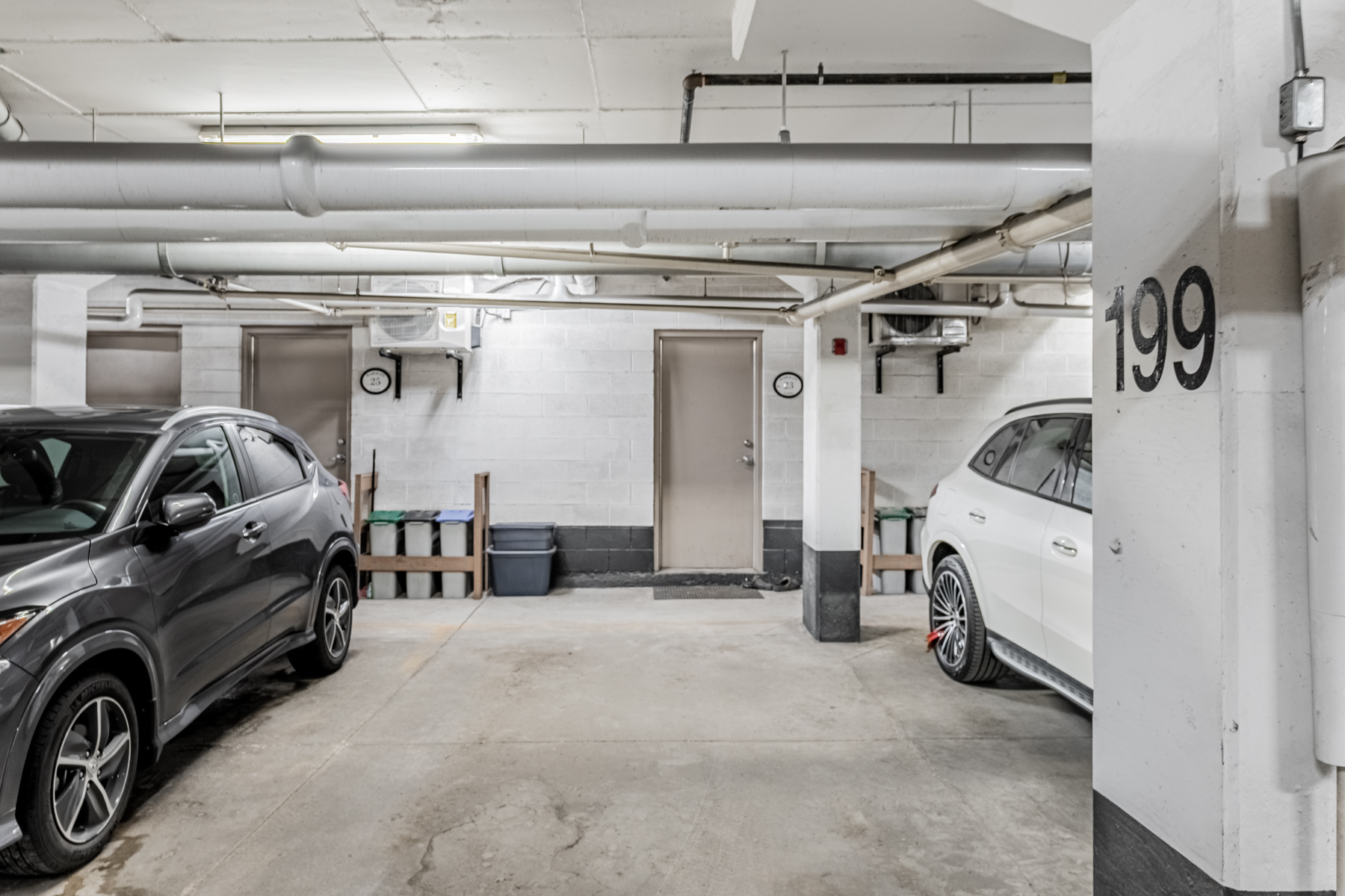 Underground parking spot with black and white vehicles.