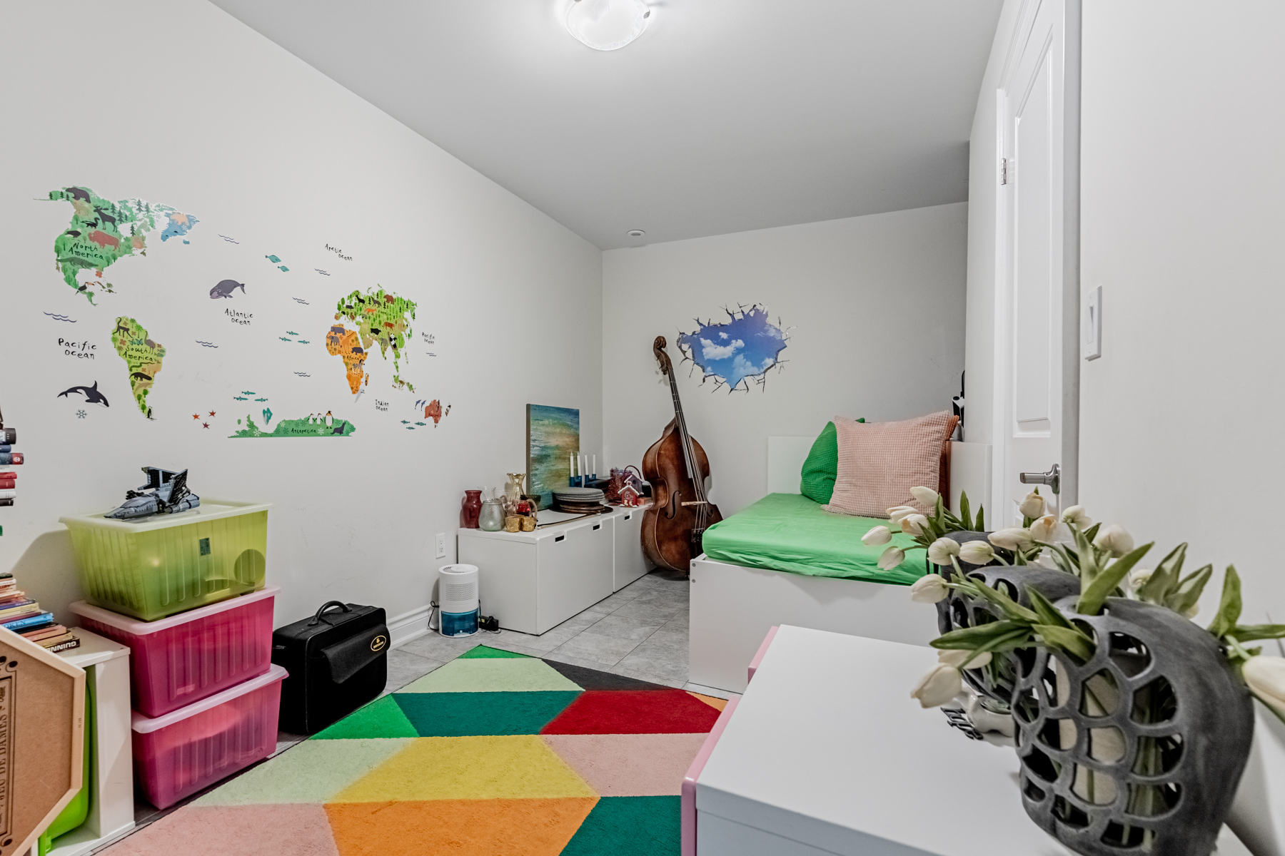 Large basement bedroom with containers and miscellaneous items.