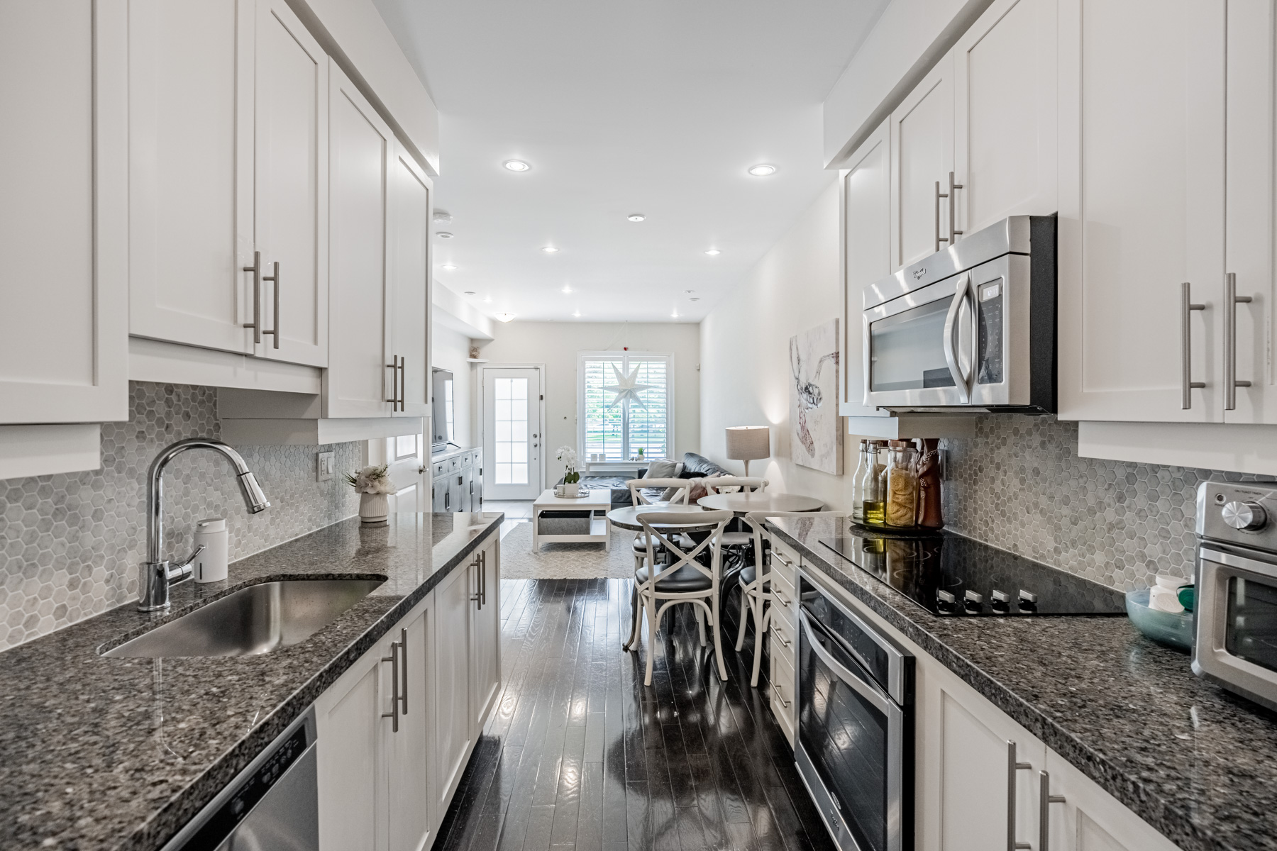 Beautiful condo townhouse kitchen with granite counters, hardwood floors and mosaic back-splash.