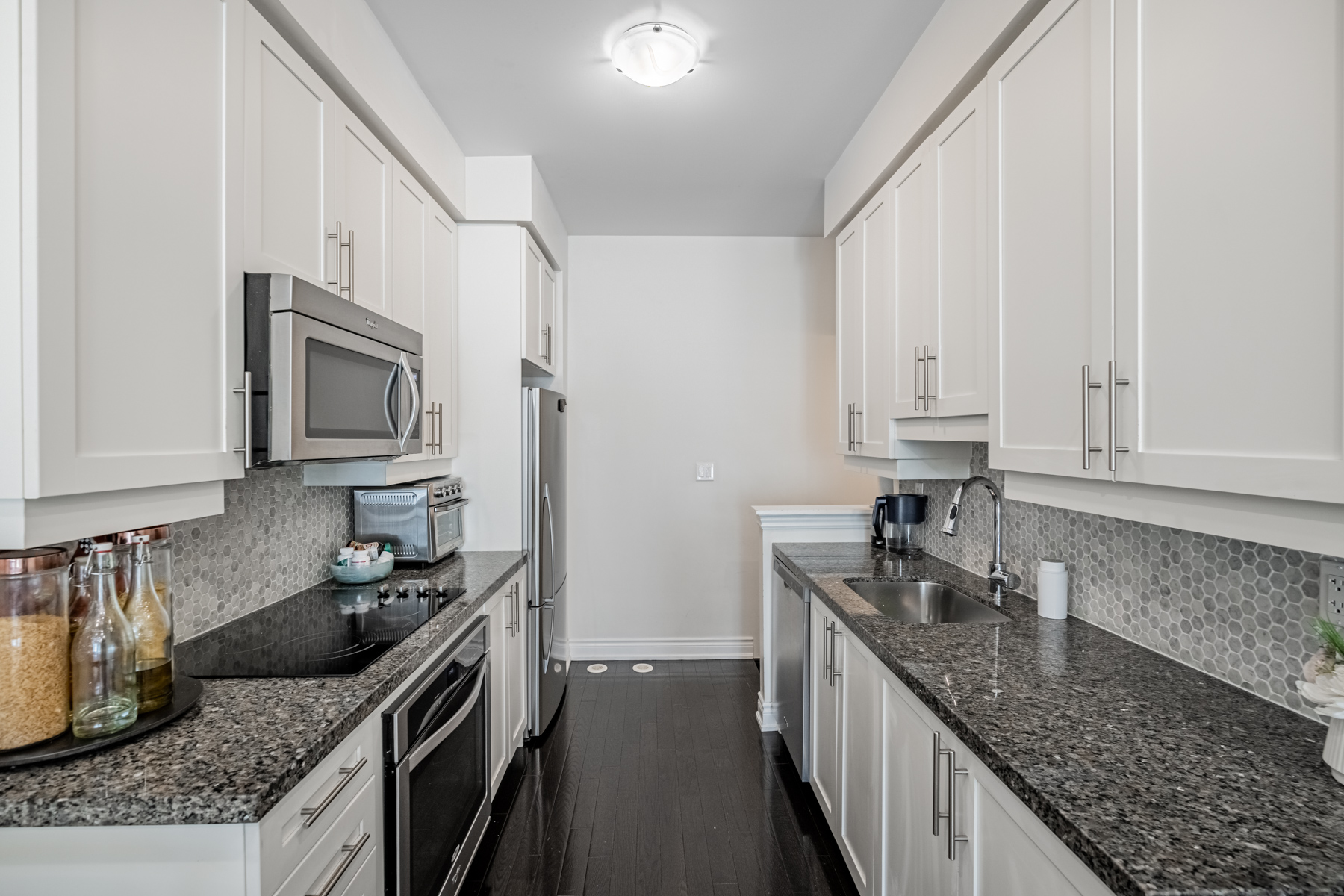 Kitchen with sleek gray cabinets with valance lighting – 2132 Bayview Ave Unit 199.