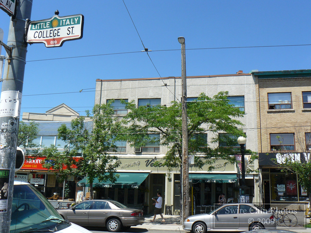 Cars and storefront along Little Italy, Toronto.