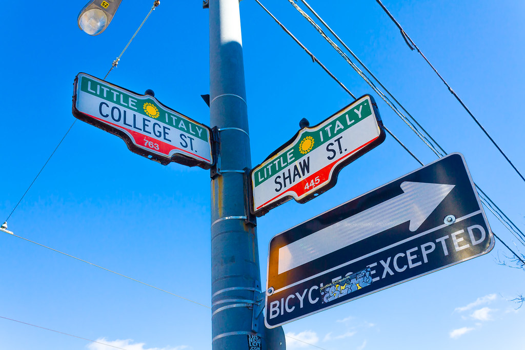 Street signs for College & Shaw Streets in Toronto's Palmerston-Little Italy neighbourhood.