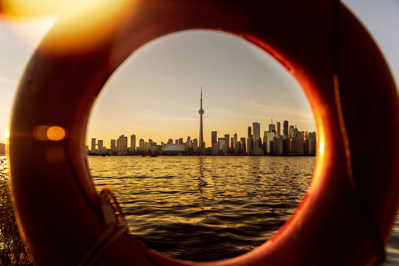 Toronto skyline and Lake Ontario at dusk seen through a life preserver.