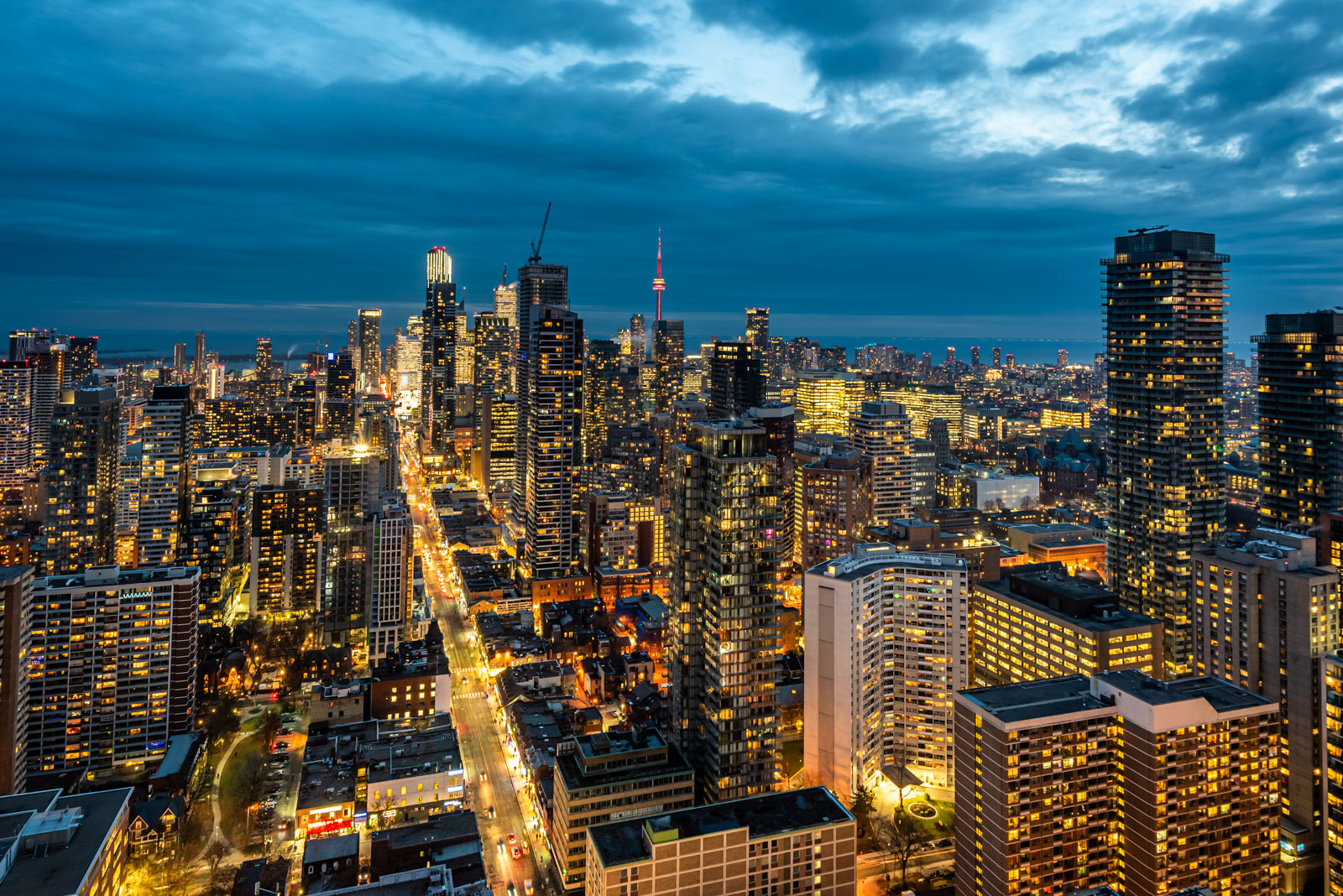 Toronto skyline at night with view of streets below, buildings and sky.
