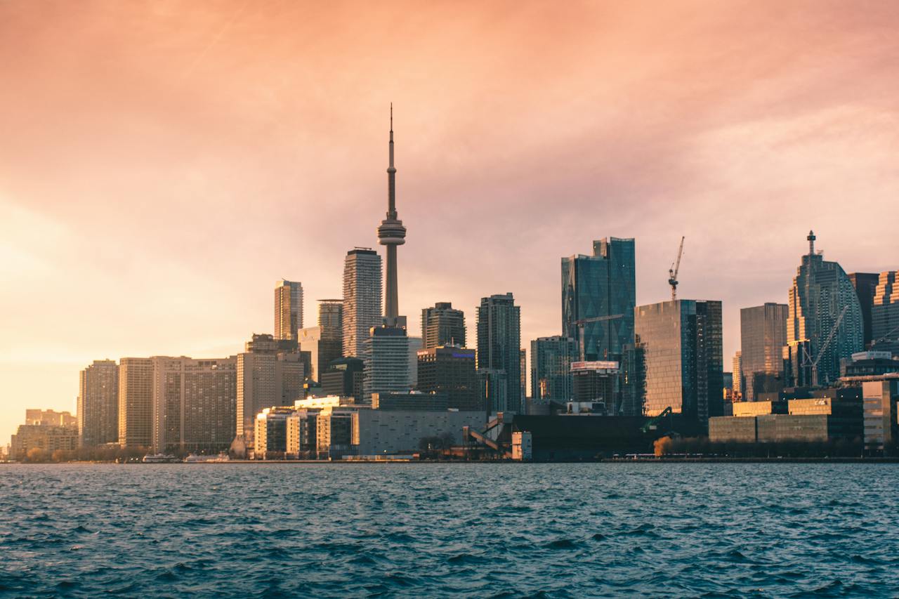 Toronto skyline seen from Lake Ontario with pink sky.
