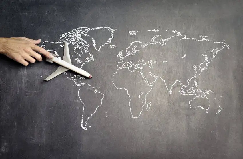 Chalk world map and airplane to show relationship between housing shortage and immigration.