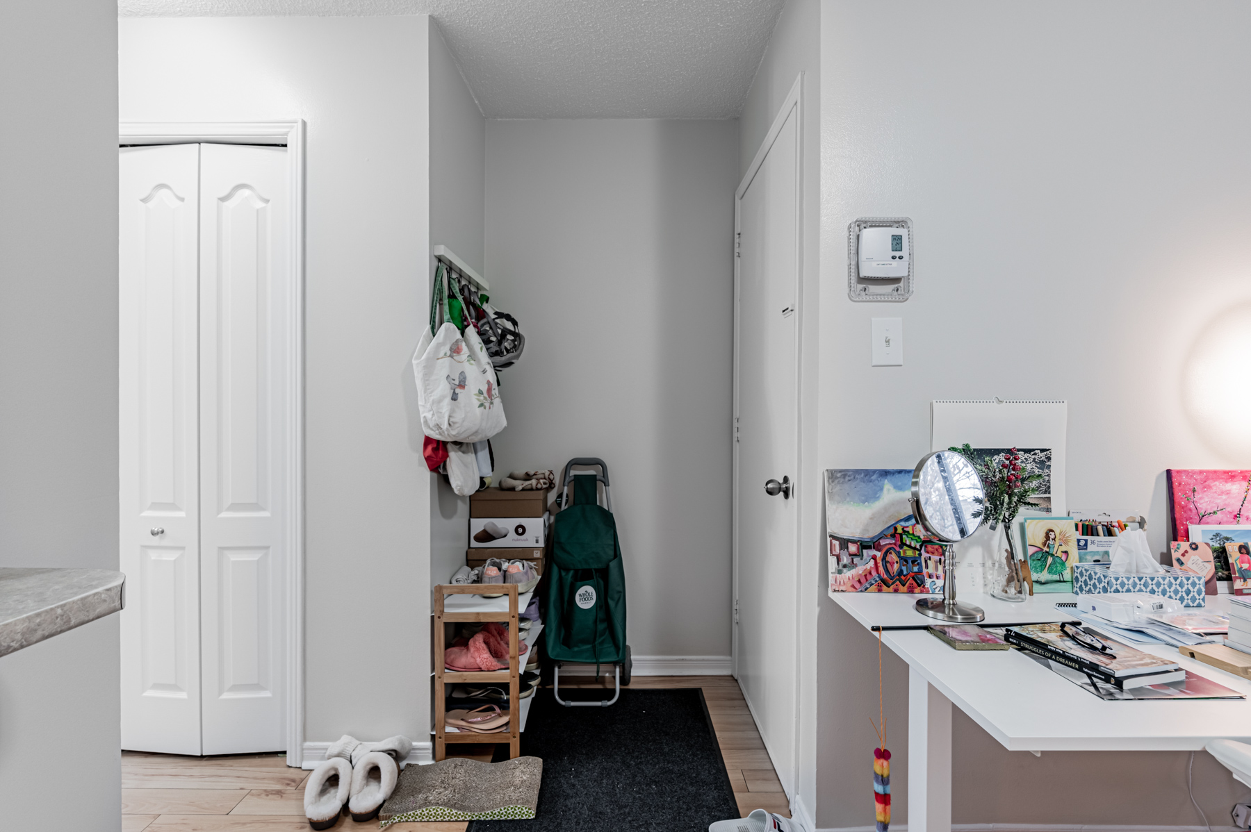 Nook with closets and shoe rack.