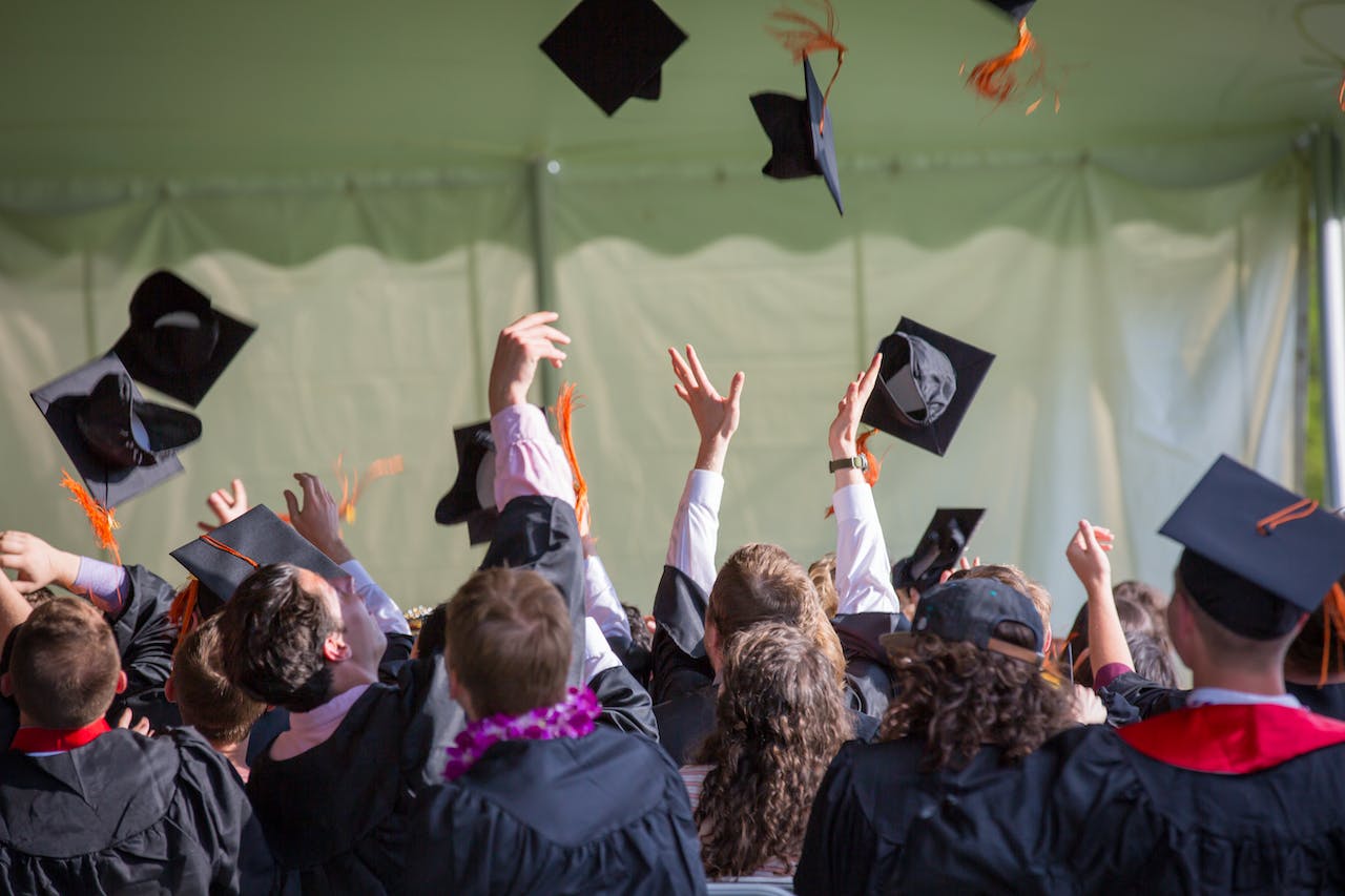 Students throwing up graduation caps. 