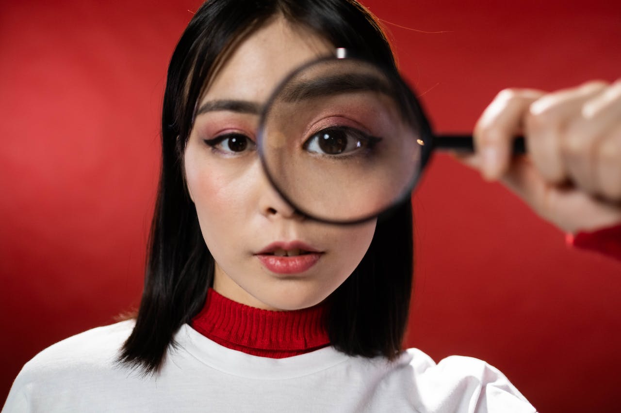 Young woman holding magnifying glass to eye showing clarity TRESA provides.