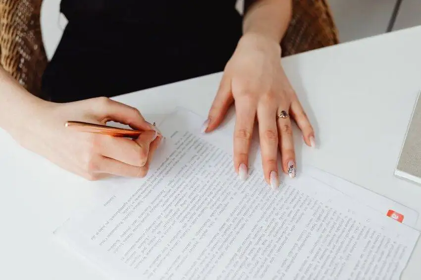 Woman signing document to show benefits of Buyer Representation Agreement (BRA).