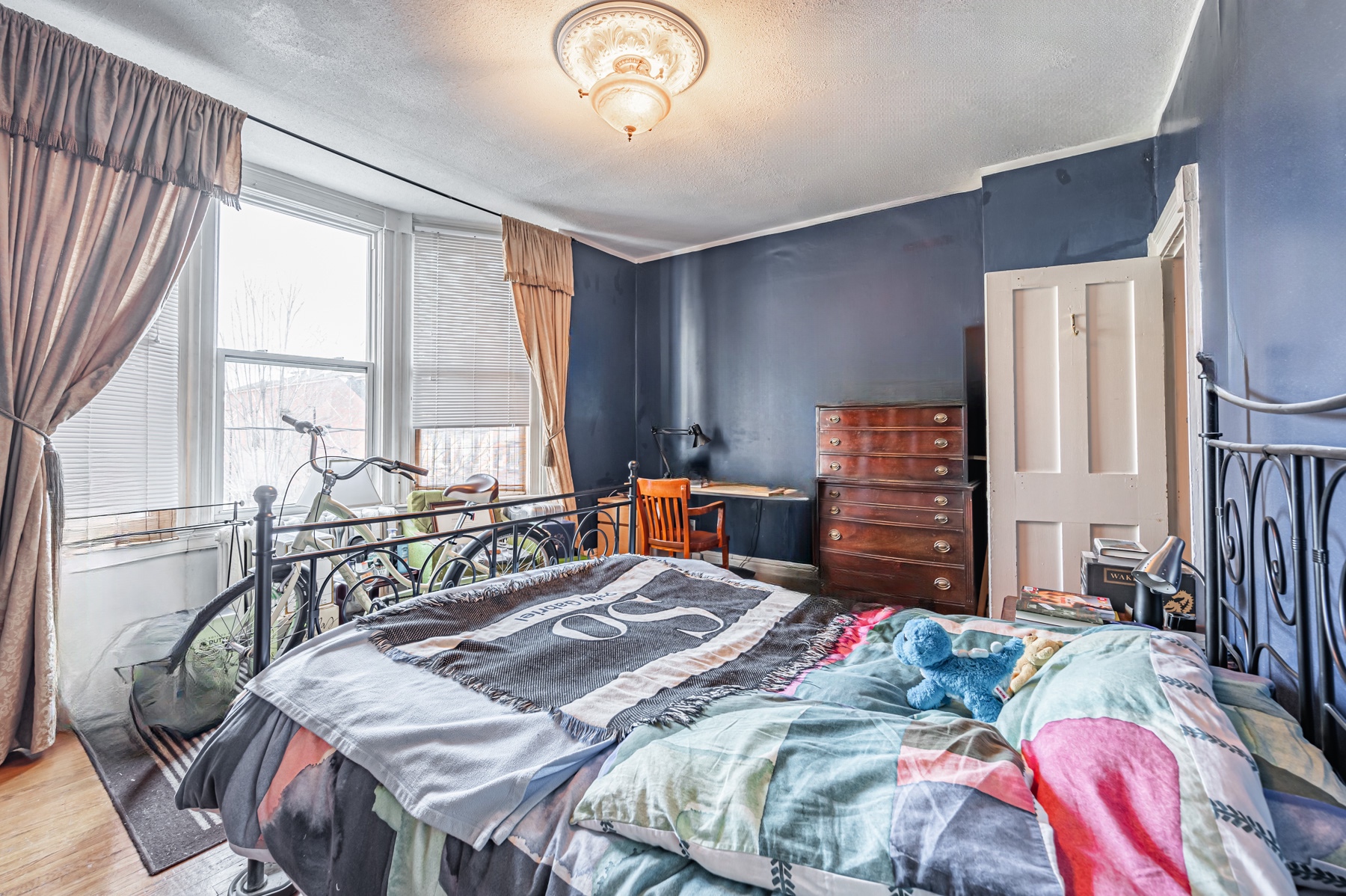 Large primary bedroom with bay windows and blue walls – 74 Homewood Ave.
