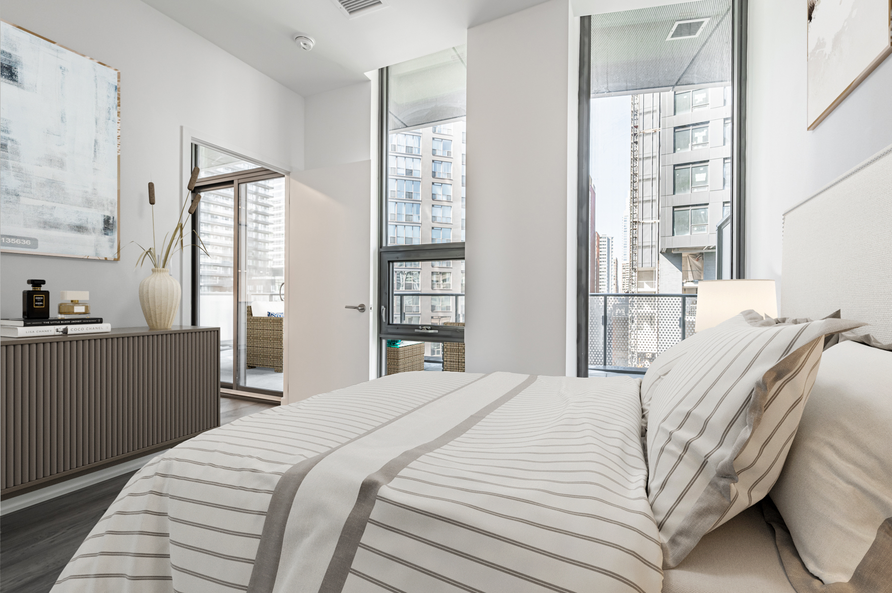 Condo bedroom with two floor-to-ceiling windows with view of Toronto.