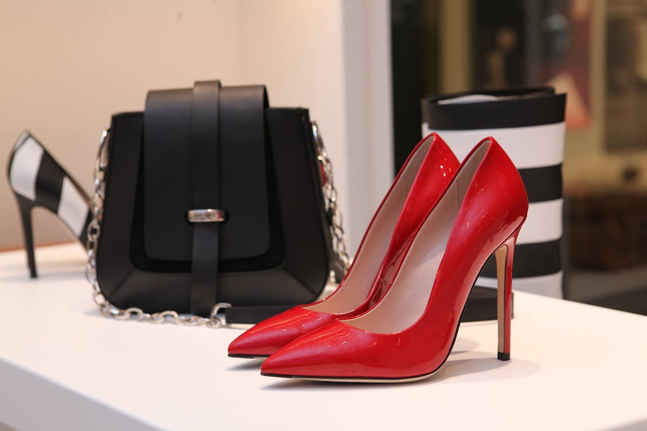 Platform with designer red shoes and black purse. 