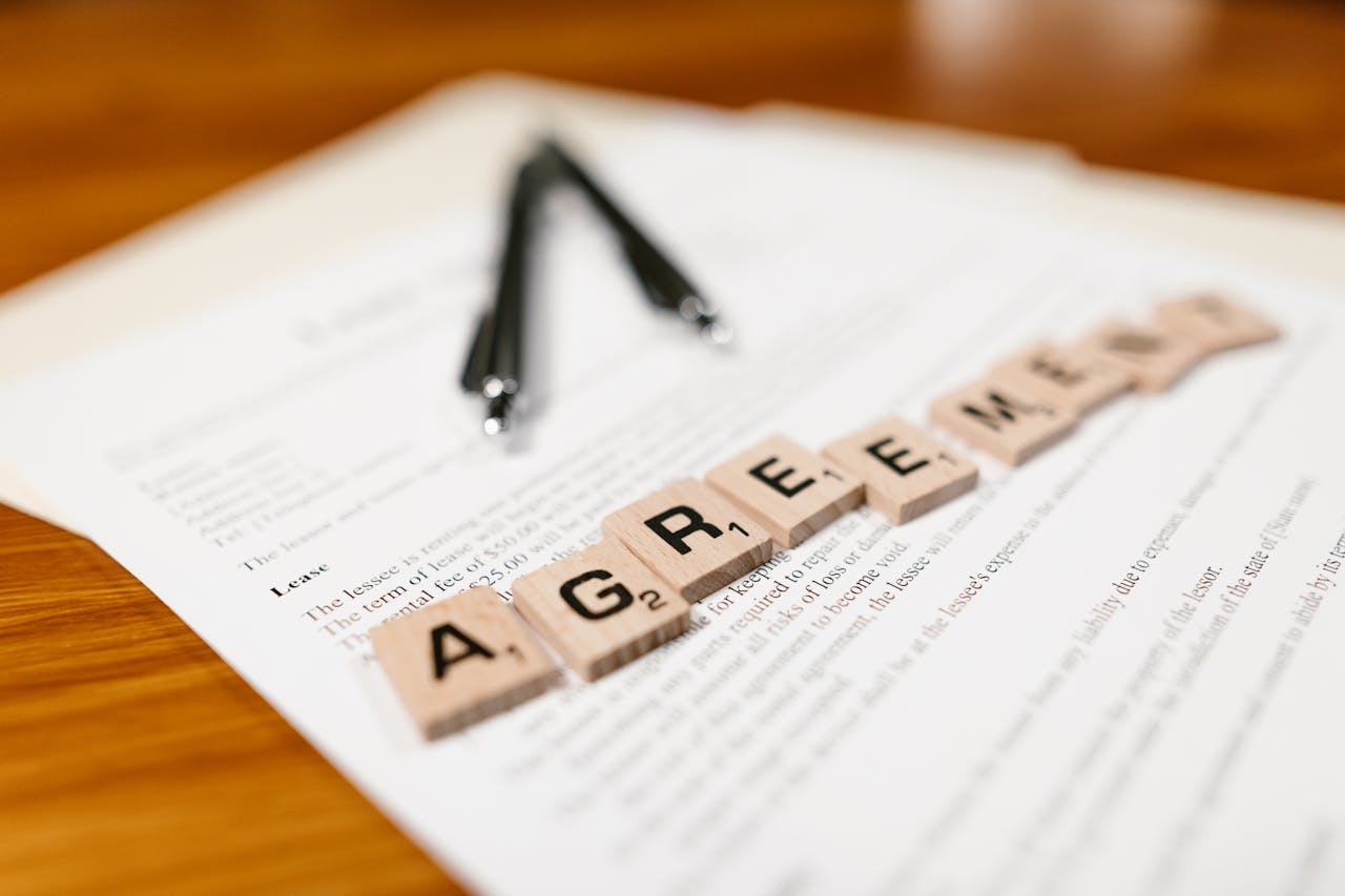 Contract with scrabble tiles spelling "Agreement."