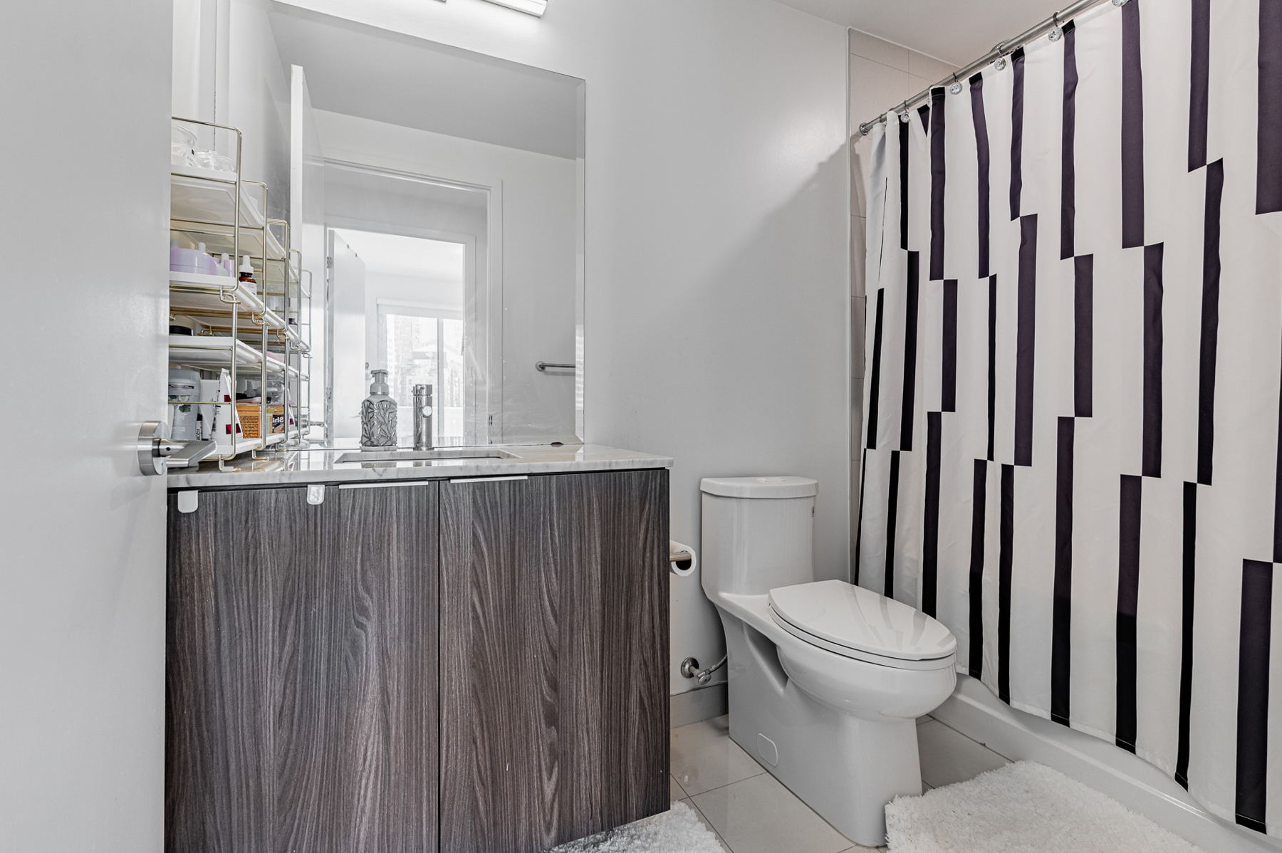 4-piece bath with tall mirror, under-sink cabinets and soaker tub – 15 Queens Quay E Unit 1605.