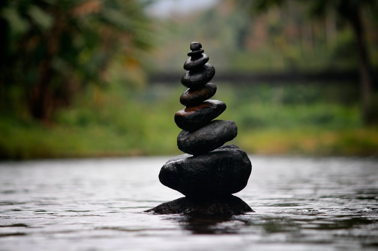 Precariously balanced pile of rocks on water.