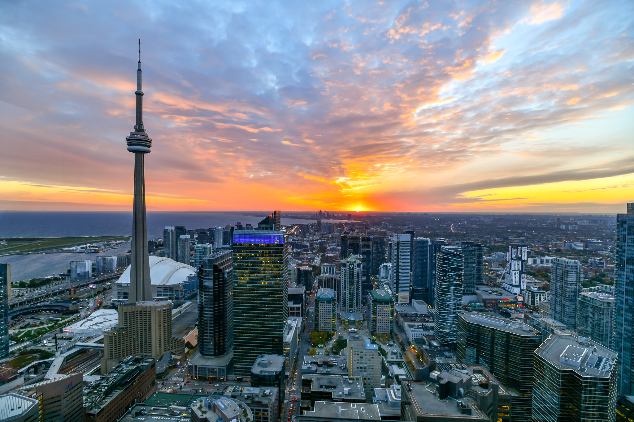 Toronto skyline at dusk with view of CN Tower and Lake Ontario.